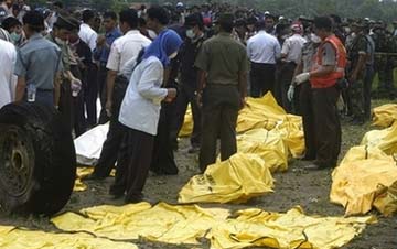 Nhân viên cứu hộ bên cạnh các túi đựng thi thể được lấy ra từ xác chiếc máy bay gặp nạn. Ảnh: AP.