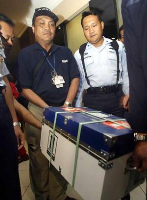 Indonesian officials carry a box containing the blackbox of a Garuda Indonesia jetliner which caught fire upon landing on Wednesday in Yogyakarta.